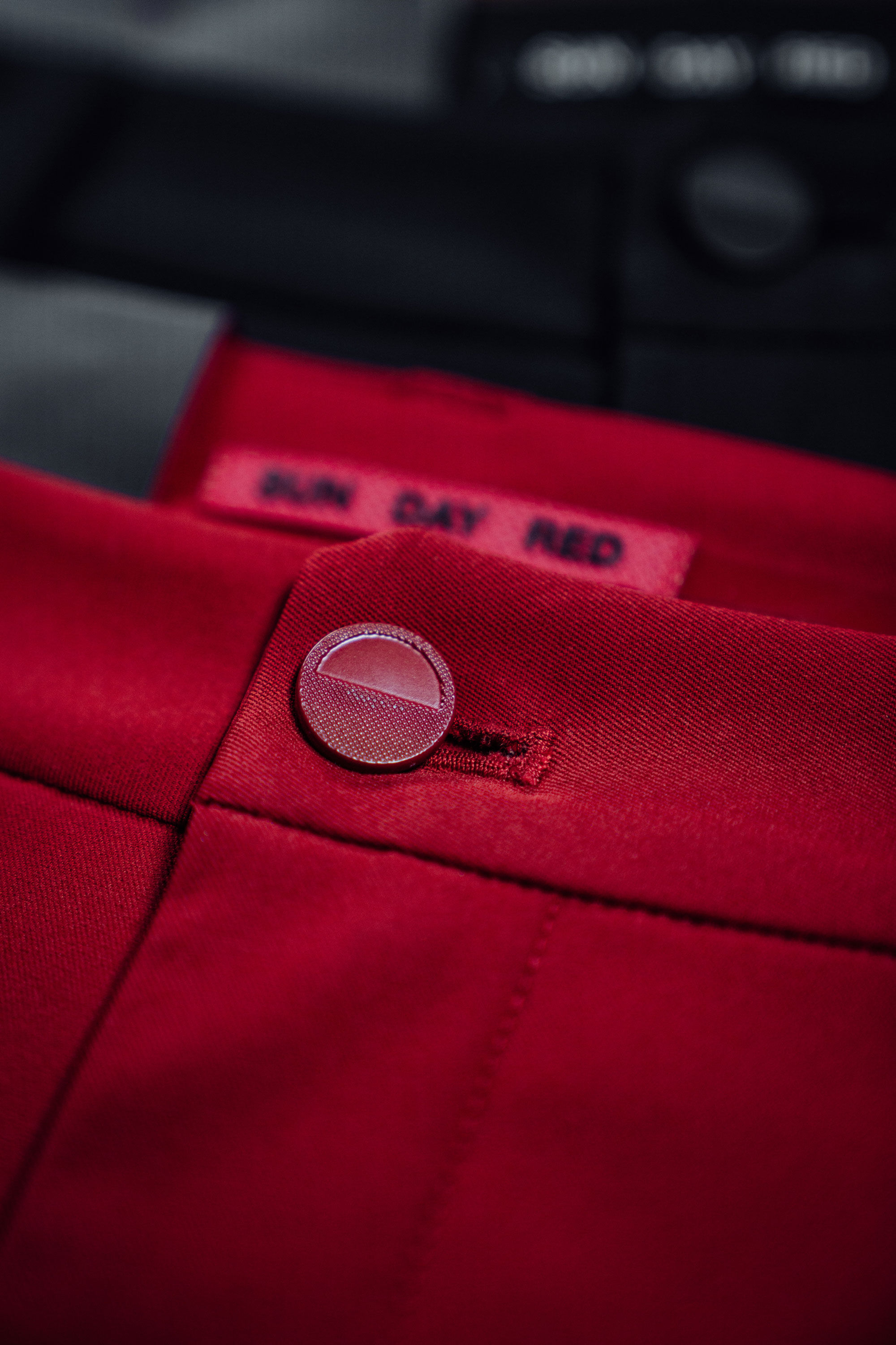 Macro detail of Sun Day Red polo buttons and placket